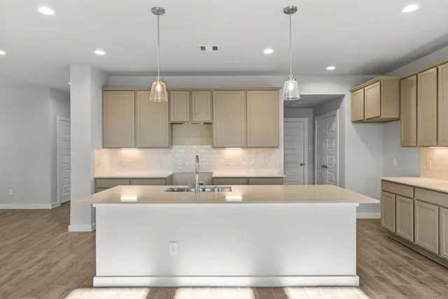 a large kitchen with kitchen island a sink stainless steel appliances and cabinets