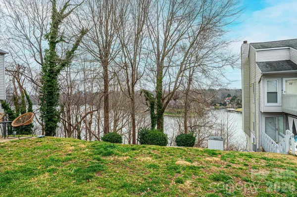 a backyard of a house with large trees and outdoor seating