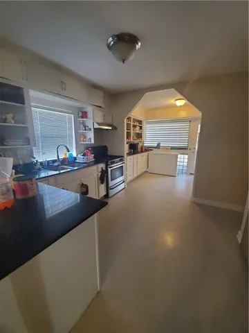 a kitchen with stainless steel appliances a stove a sink refrigerator and a fireplace