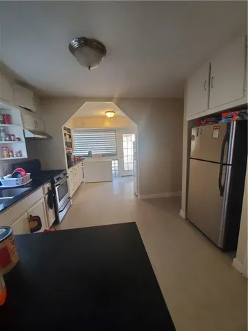 a view of a kitchen with fridge and workspace