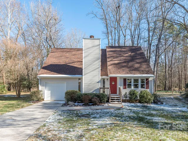 a front view of house with yard and trees around