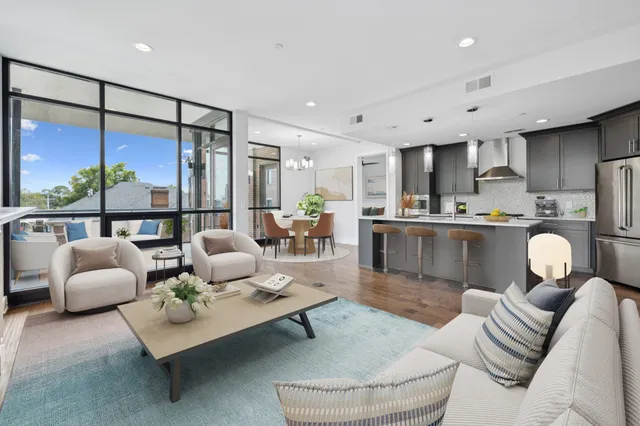 a living room with furniture kitchen view and a large window