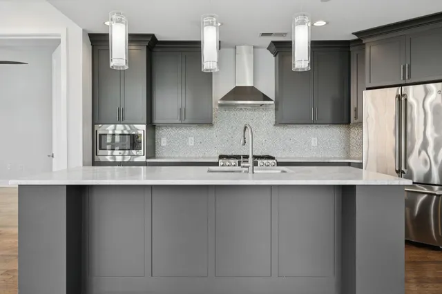 an empty room with wooden floor closet and windows
