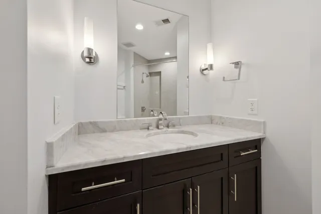 a kitchen with stainless steel appliances a stove a chimney a sink and cabinets