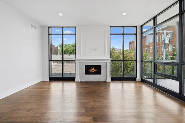 a kitchen with stainless steel appliances granite countertop a refrigerator a sink dishwasher a stove and white countertops with wooden floor