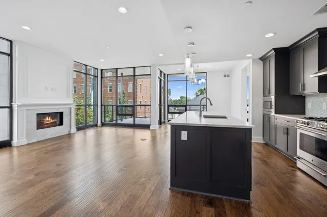 a view of kitchen with kitchen island stainless steel appliances cabinets and wooden floor