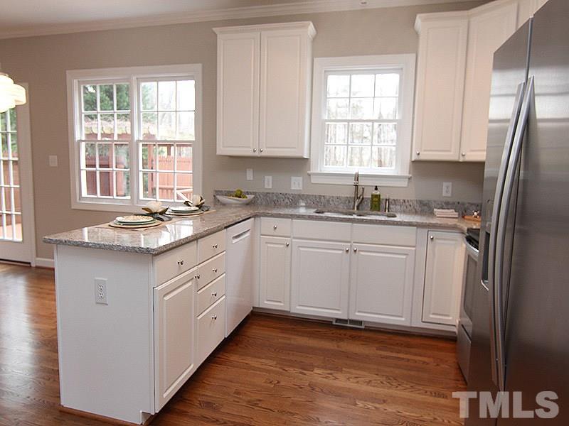 2617 Jasper Lane Raleigh, NC 27613 - Photo 12 of 25 a kitchen with granite countertop white cabinets white appliances a sink and a window