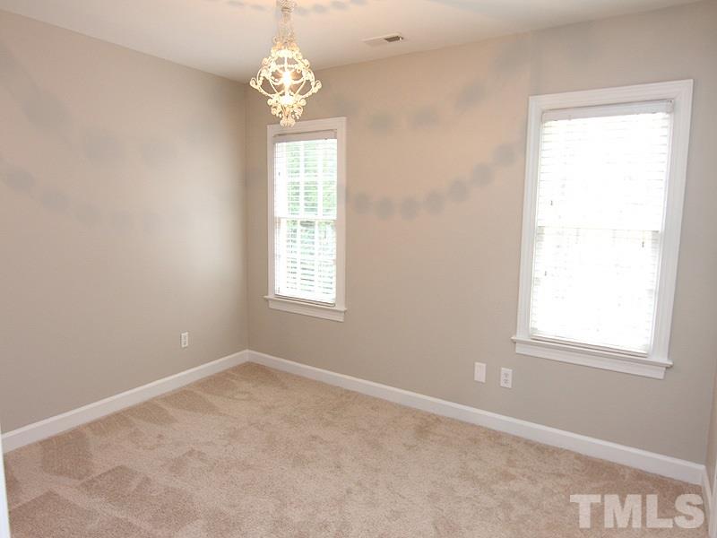 2617 Jasper Lane Raleigh, NC 27613 - Photo 19 of 25 an empty room with windows and chandelier