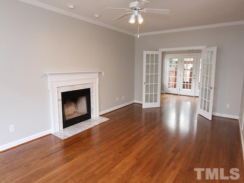 2617 Jasper Lane Raleigh, NC 27613 - Photo 7 of 25 a view of an empty room with wooden floor and a fireplace