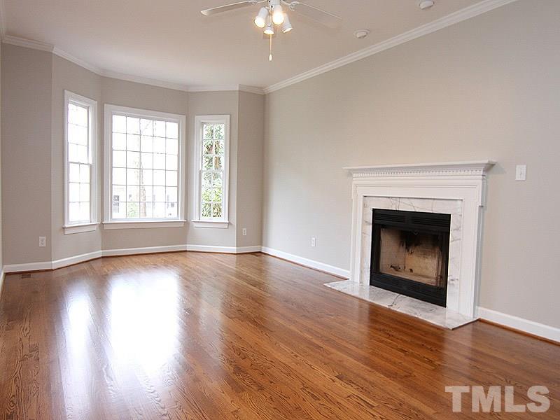 2617 Jasper Lane Raleigh, NC 27613 - Photo 8 of 25 a view of an empty room with wooden floor fireplace and a window