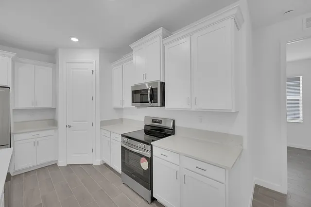 a kitchen with white cabinets and stainless steel appliances