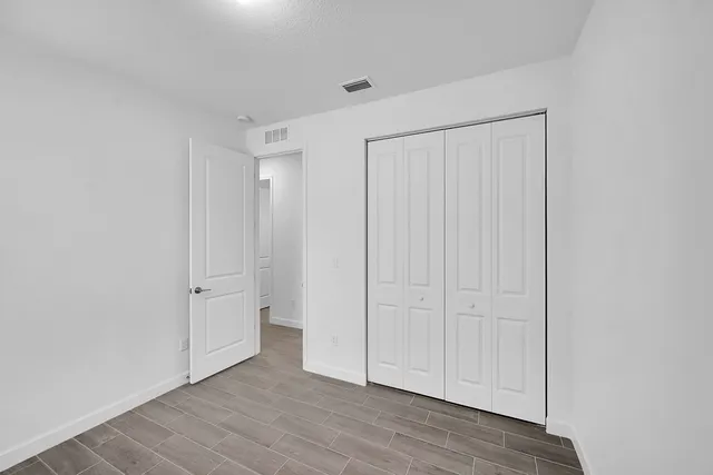 a view of room with hardwood floor and white cabinet
