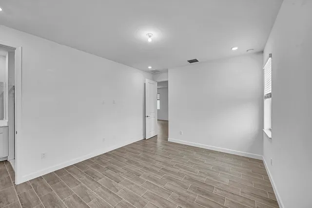 a view of an empty room with wooden floor