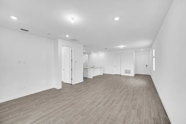 a view of an empty room with wooden floor