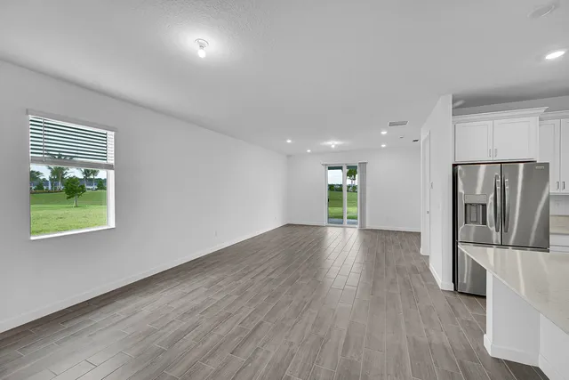 an empty room with wooden floor and a window