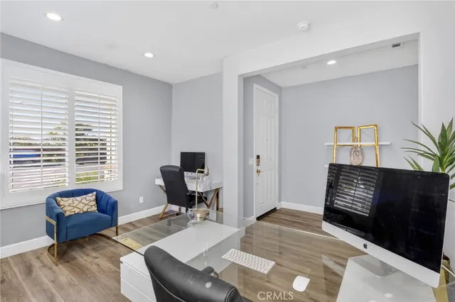 a open kitchen with stainless steel appliances kitchen island granite countertop a stove a refrigerator a sink dishwasher and a dining table with wooden floor