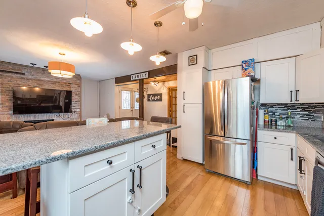 a kitchen with stainless steel appliances granite countertop a refrigerator and a sink