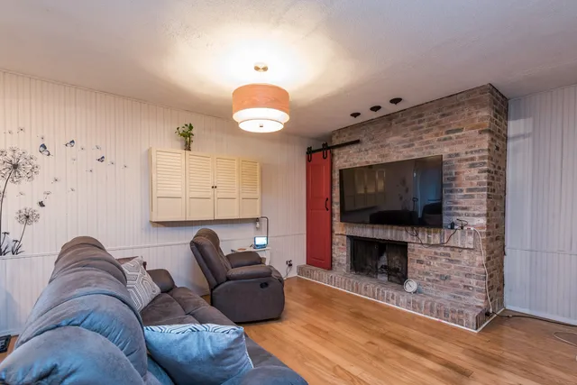 a living room with furniture a flat screen tv and a fireplace