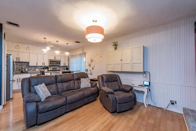 a living room with furniture and kitchen view