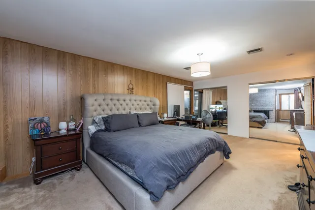 a bedroom with a large bed and a fireplace