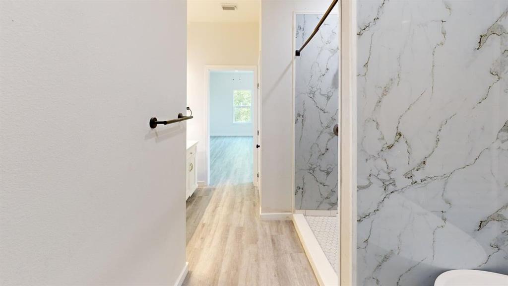 6702 South Lancaster Road Dallas, TX 75241 - Photo 16 of 20 Shower with a white marble-look surround, hexagonal tile floor, and dark bronze fixtures