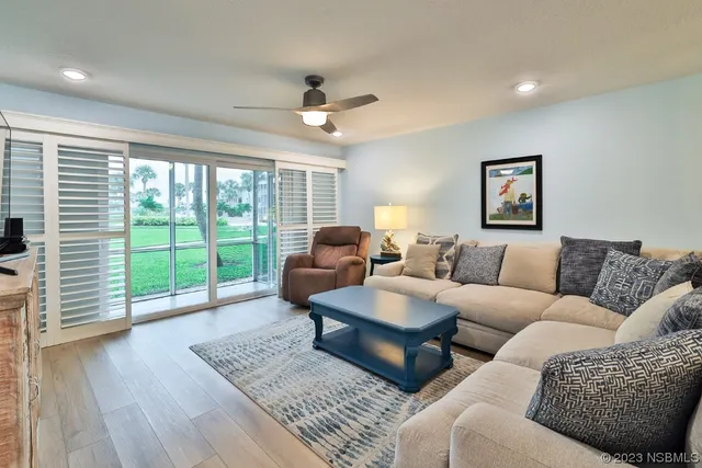 a living room with furniture and a wooden floor
