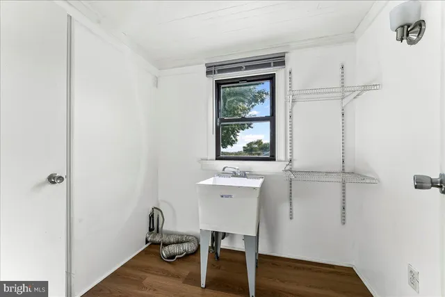 a view of a workspace with wooden floor and a window