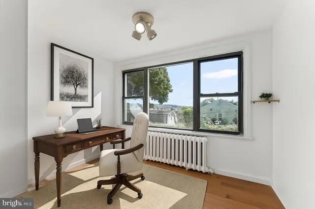 a view of a workspace with furniture and a window