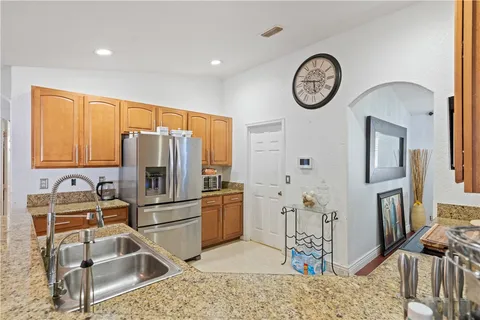 a kitchen with stainless steel appliances kitchen island granite countertop a refrigerator and a stove top oven