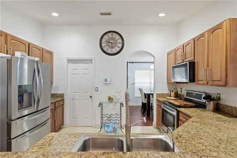 a kitchen with stainless steel appliances granite countertop a refrigerator and a sink