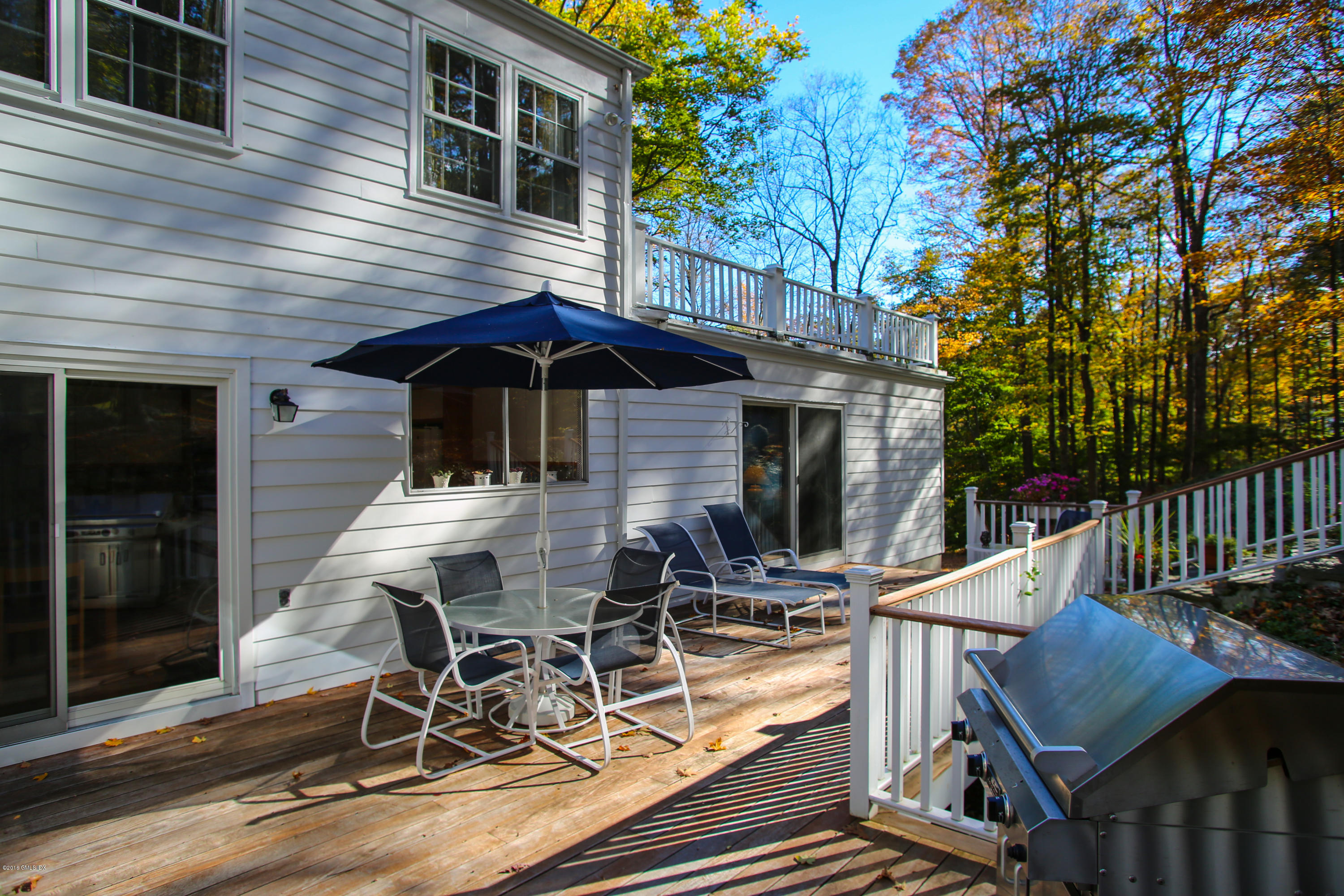 36 Burning Tree Road Greenwich, CT 06830 - Photo 21 of 25 a view of a patio with table and chairs with wooden floor and fence
