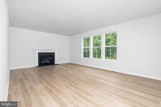 an empty room with wooden floor and a window