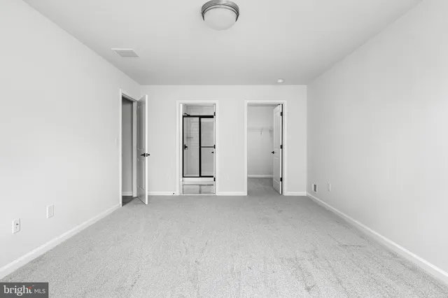 an empty room with closet and mirror