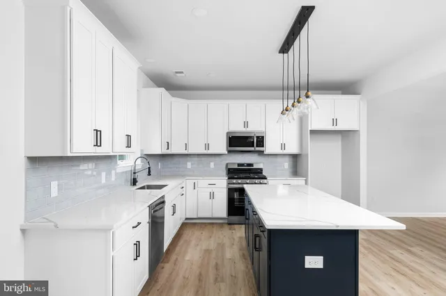 a kitchen with stainless steel appliances kitchen island a white cabinets sink and stove
