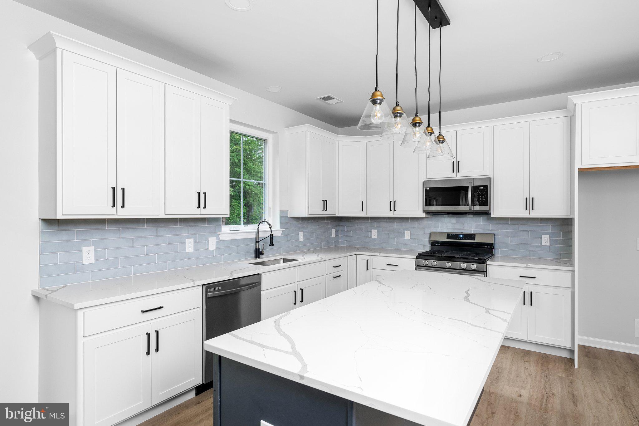 4913 South Broad Street Hamilton, NJ 08620 - Photo 9 of 31 a kitchen with stainless steel appliances a white cabinets and wooden floor
