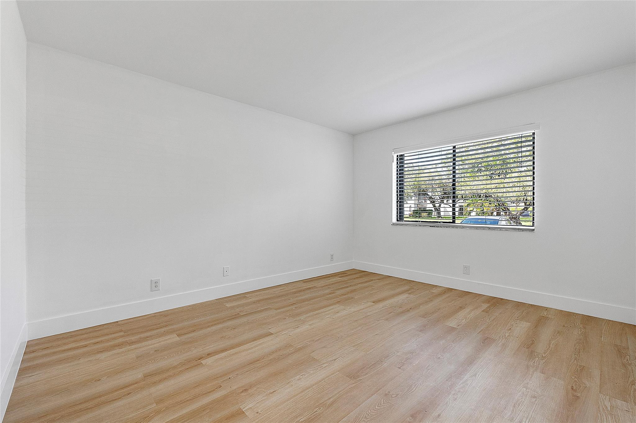 300 Racquet Club Road, Unit 105 Weston, FL 33326 - Photo 11 of 14 an empty room with wooden floor and windows