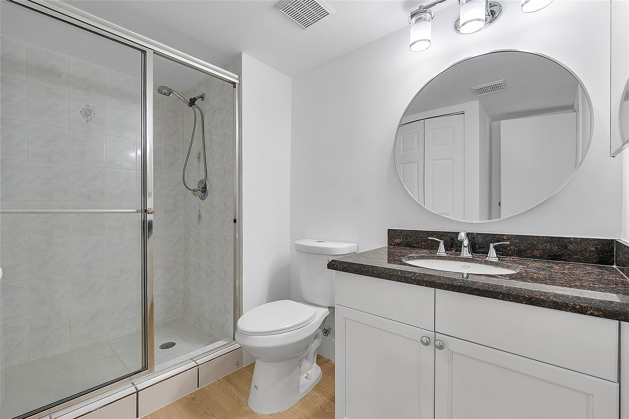 300 Racquet Club Road, Unit 105 Weston, FL 33326 - Photo 12 of 14 a bathroom with a granite countertop sink mirror vanity and toilet