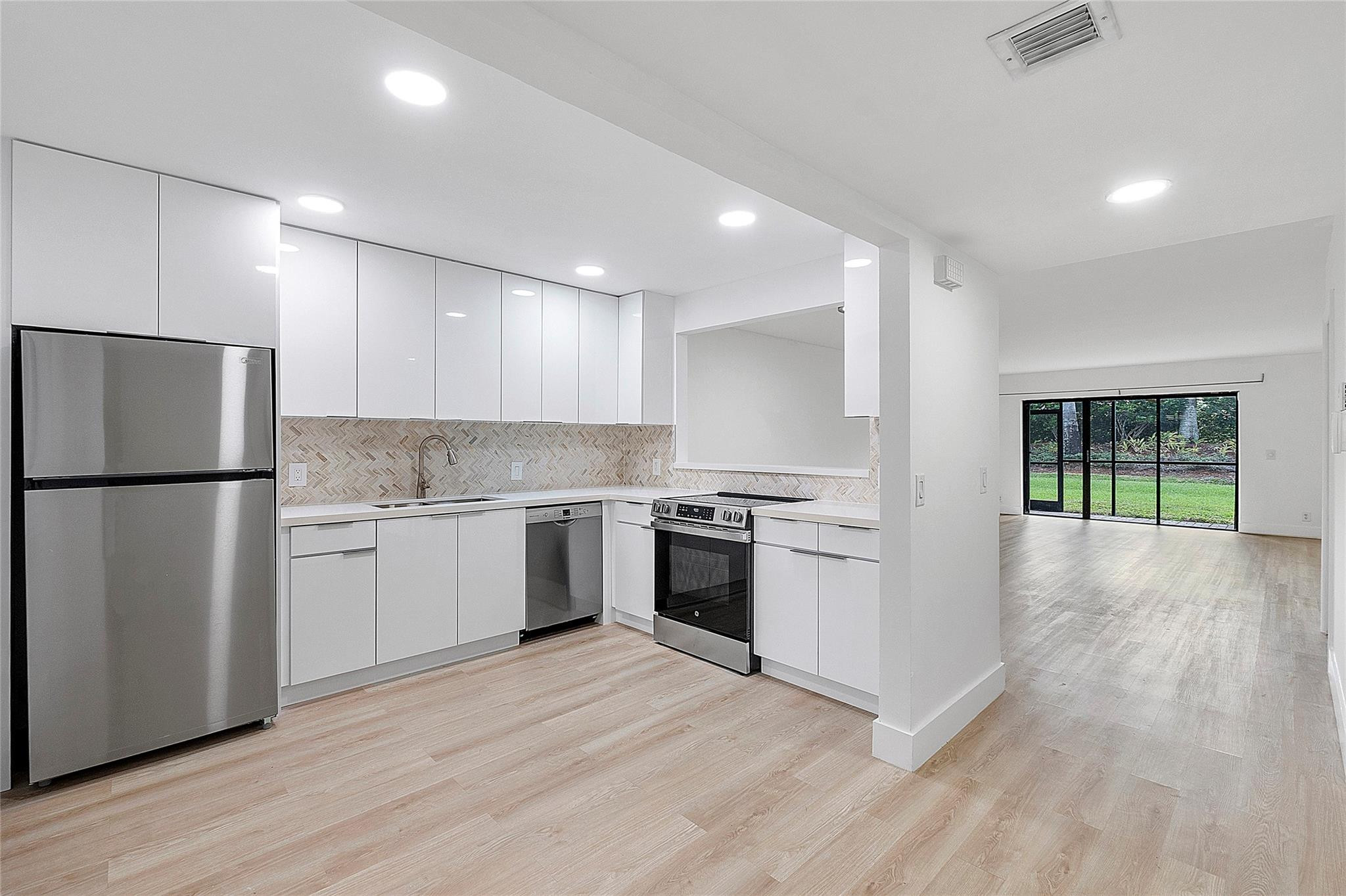 300 Racquet Club Road, Unit 105 Weston, FL 33326 - Photo 2 of 14 a kitchen with a refrigerator stove and wooden floor