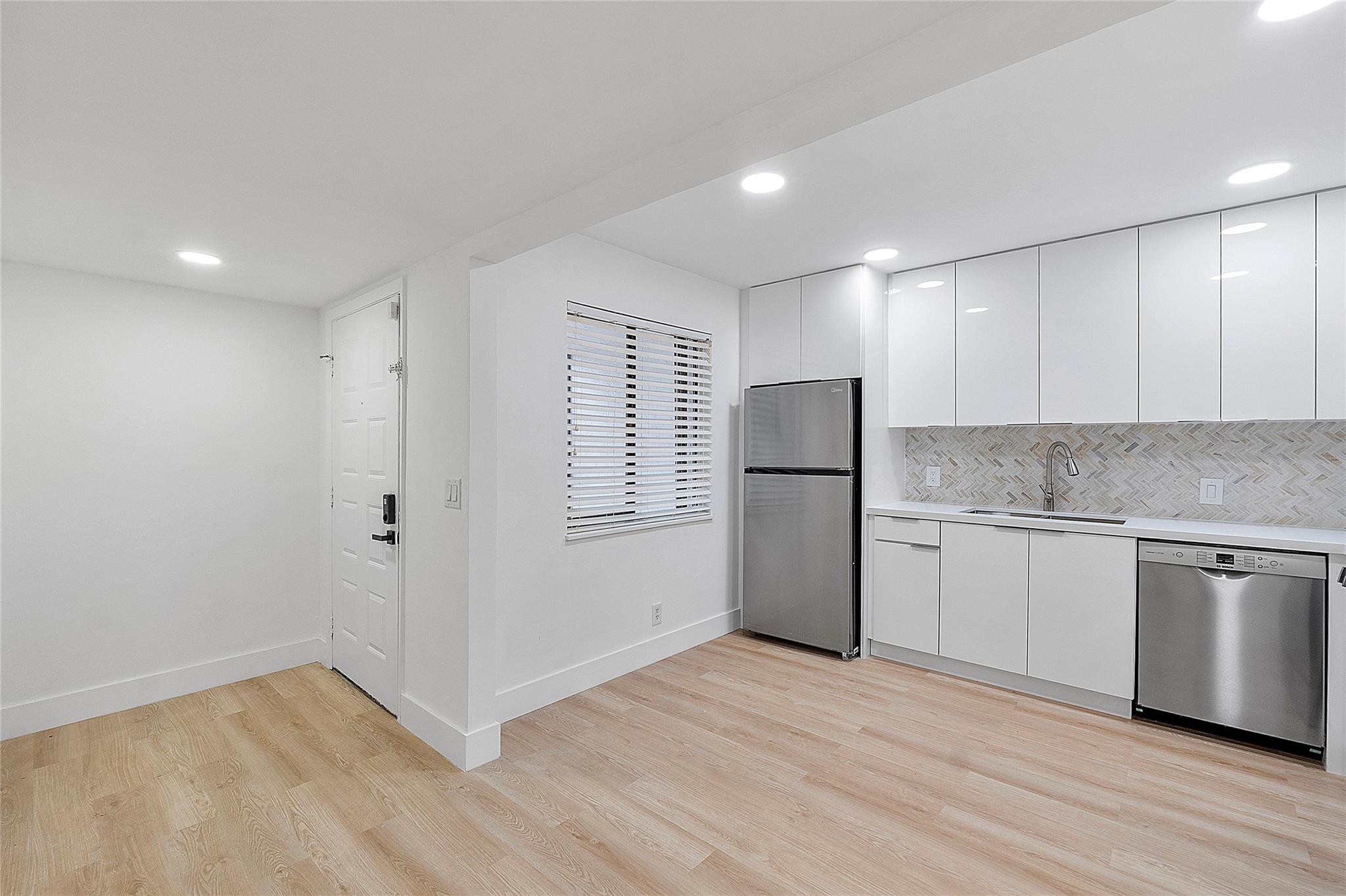 300 Racquet Club Road, Unit 105 Weston, FL 33326 - Photo 3 of 14 a kitchen with granite countertop white cabinets and refrigerator