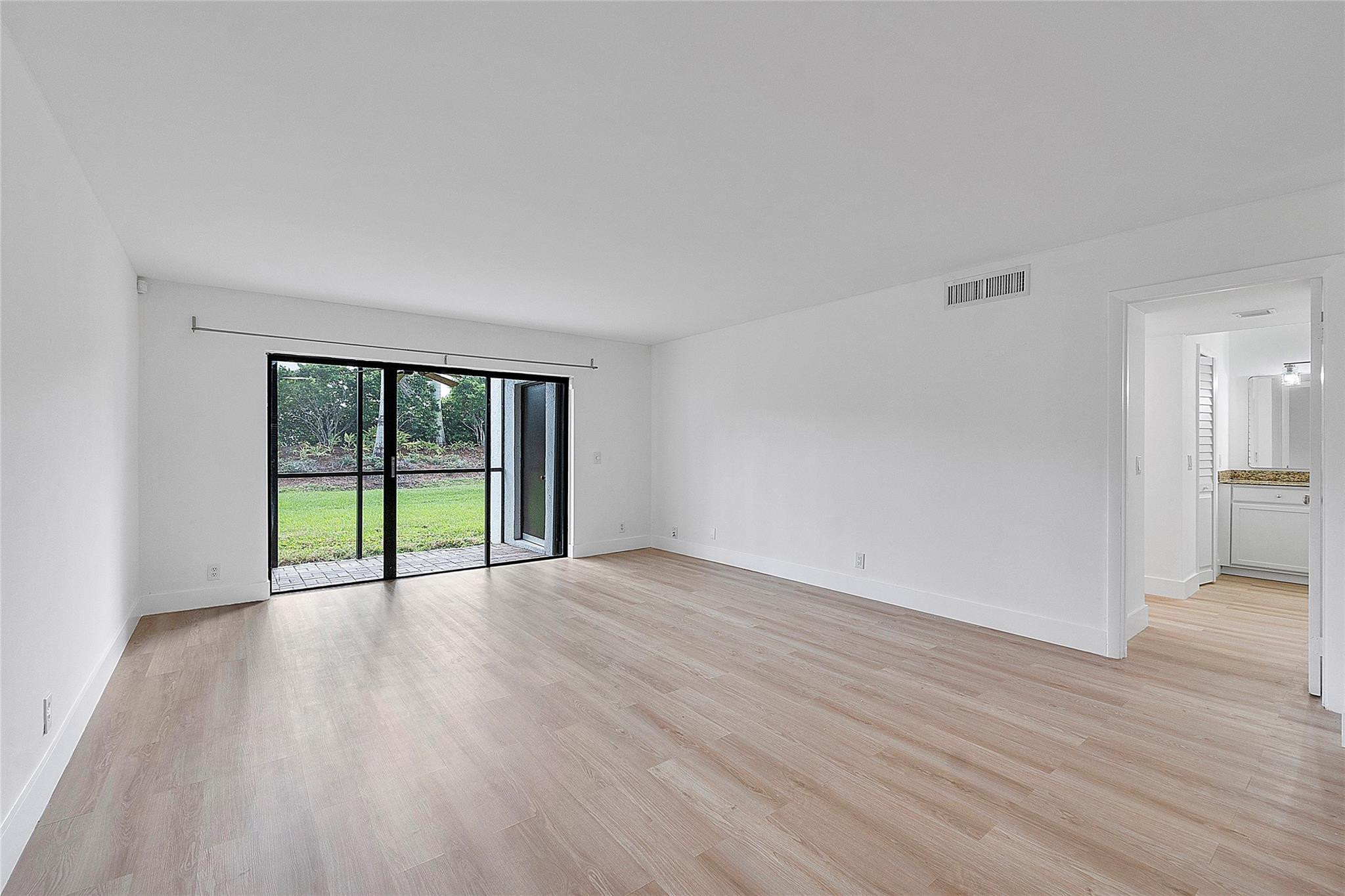 300 Racquet Club Road, Unit 105 Weston, FL 33326 - Photo 6 of 14 a view of an empty room with wooden floor and a window
