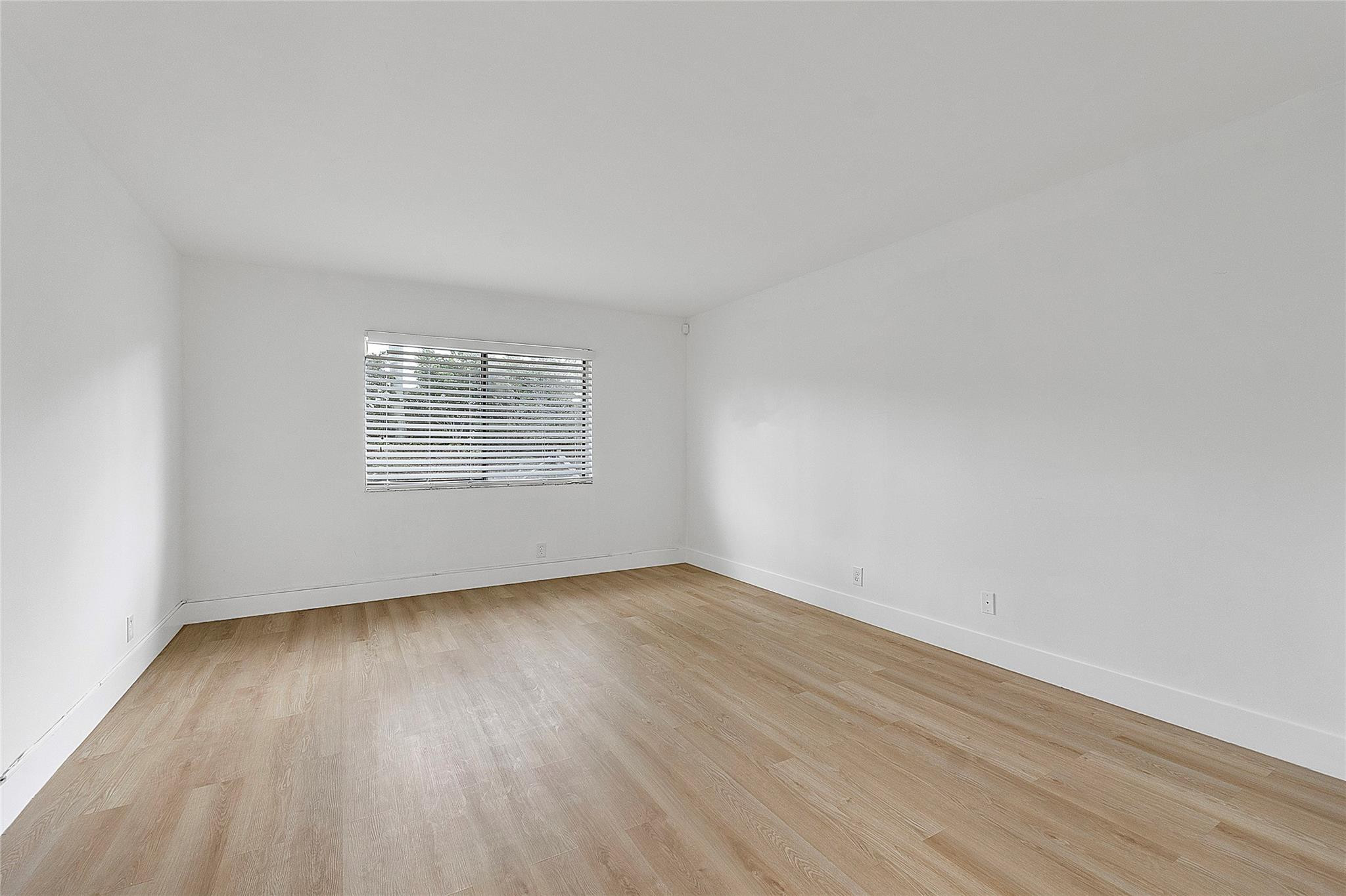 300 Racquet Club Road, Unit 105 Weston, FL 33326 - Photo 8 of 14 an empty room with wooden floor and windows