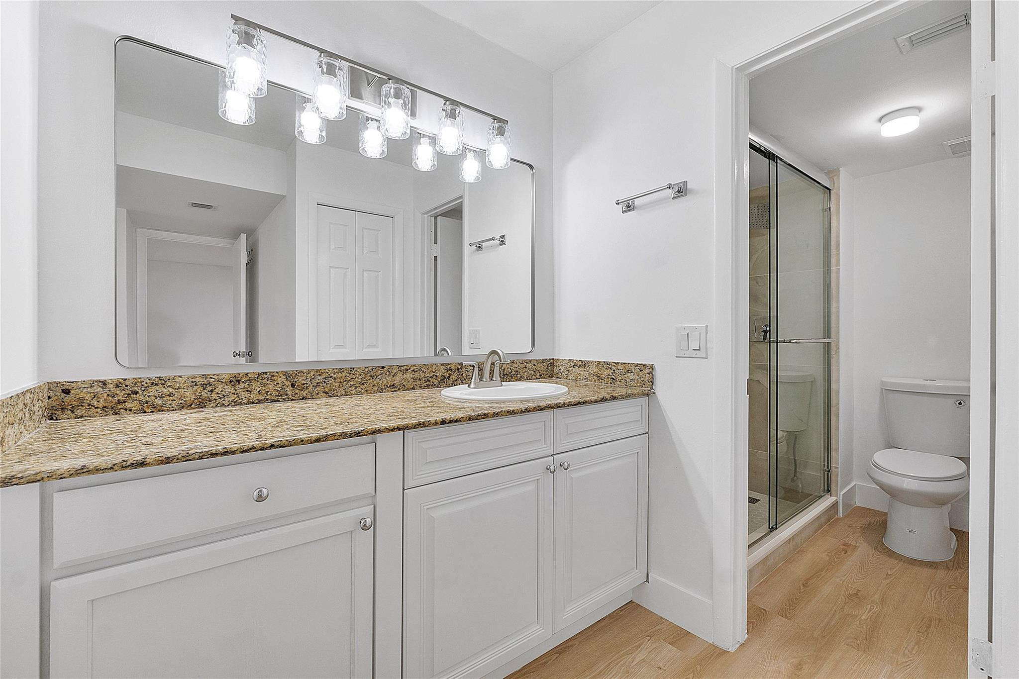 300 Racquet Club Road, Unit 105 Weston, FL 33326 - Photo 9 of 14 a bathroom with a granite countertop sink a toilet and shower
