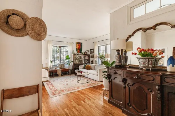 a living room with furniture a chandelier and a mirror