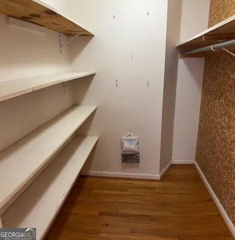a view of walk in closet with clothes and shoes