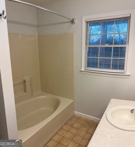 a white bath tub sitting next to a white toilet and a shower