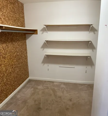 a view of walk in closet with empty racks