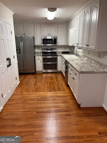 a kitchen with stainless steel appliances granite countertop a refrigerator a stove top oven a sink and dishwasher