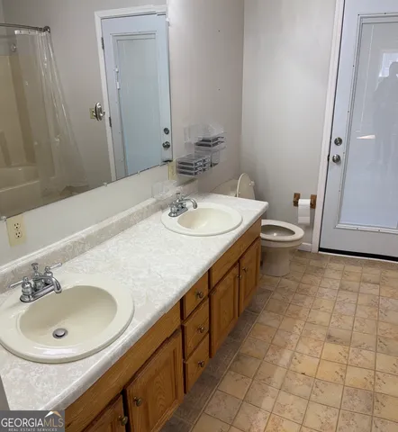 a bathroom with a sink a toilet and a mirror