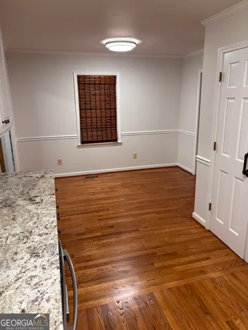 a view of a room with wooden floor and white walls