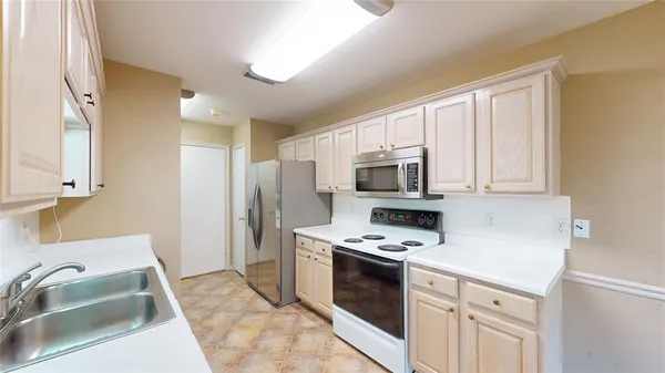 a kitchen with stainless steel appliances granite countertop a refrigerator sink and stove